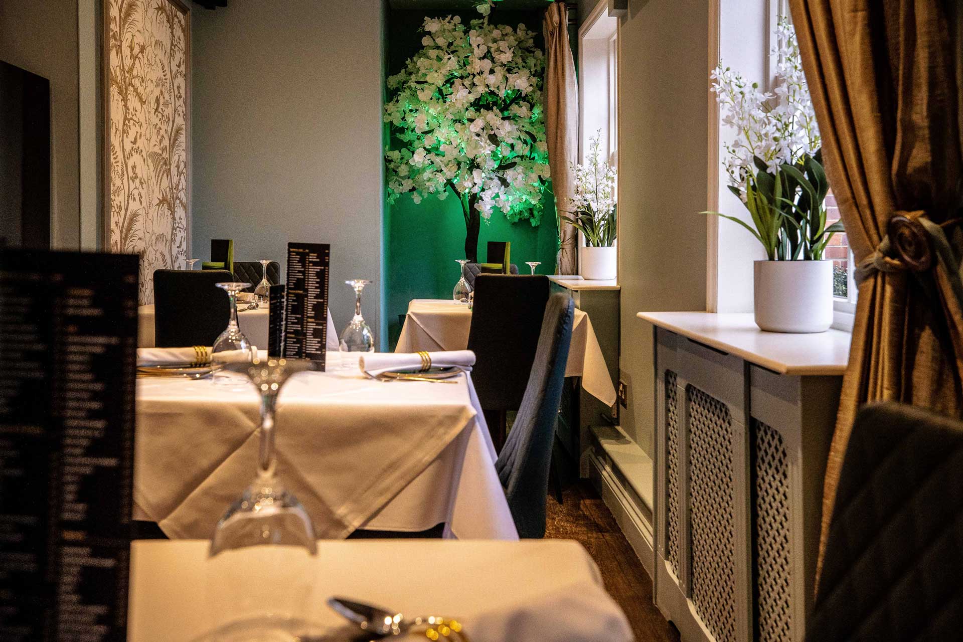 Ruby dining room with crisp table settings and warm ambient lighting
